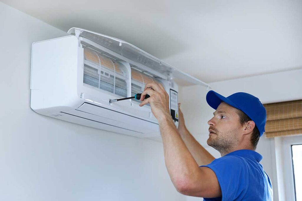 A family adjusting a wall-mounted digital thermostat in a modern living room with visible HVAC vent.